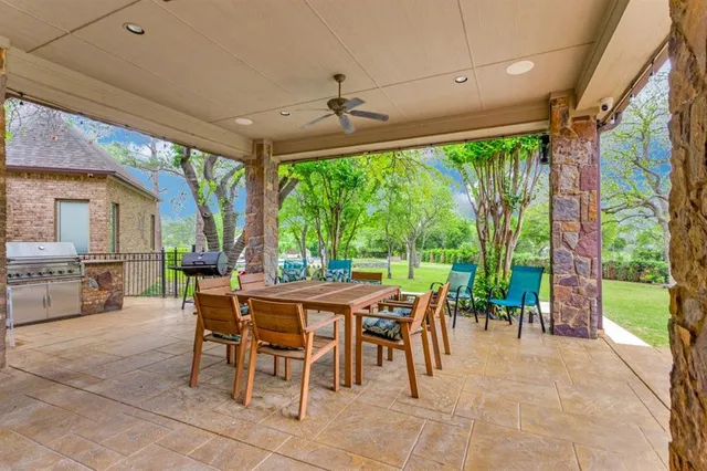 a view of a backyard with table and chairs potted plants and tree