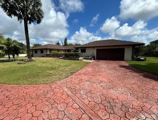 a front view of a house with yard and trees