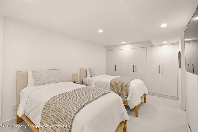 a spacious bedroom with two beds and a lamp