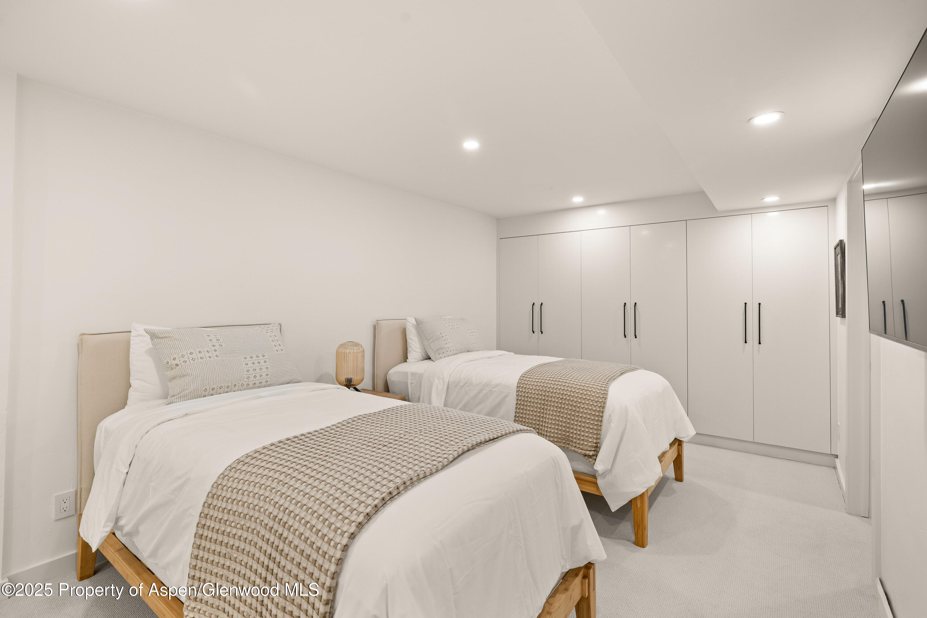 814 West Bleeker Street, Unit B2 Aspen, CO 81611 - Photo 13 of 17 a spacious bedroom with two beds and a lamp