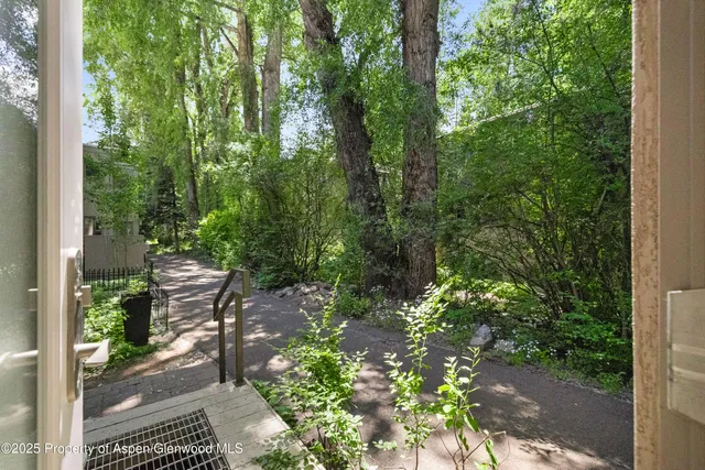 a backyard of a house with lots of green space and glass windows