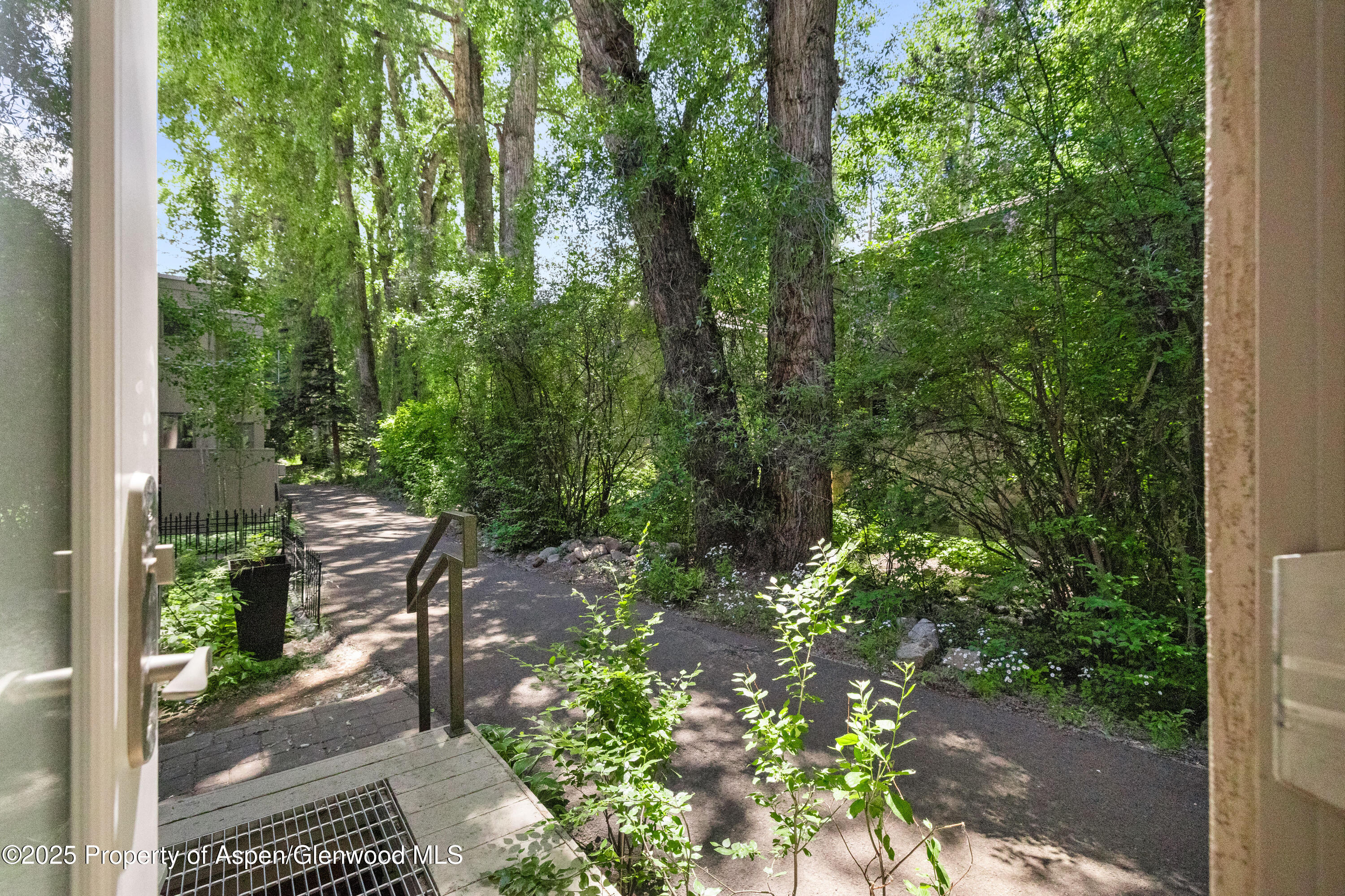 814 West Bleeker Street, Unit B2 Aspen, CO 81611 - Photo 17 of 17 a backyard of a house with lots of green space and glass windows