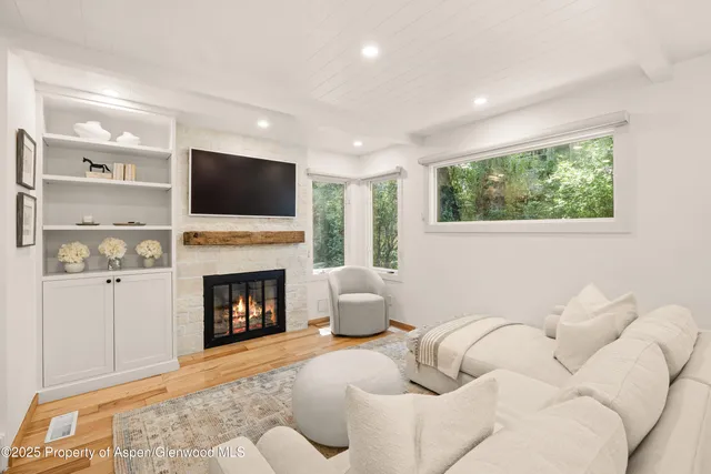 a living room with furniture a fireplace and a flat screen tv