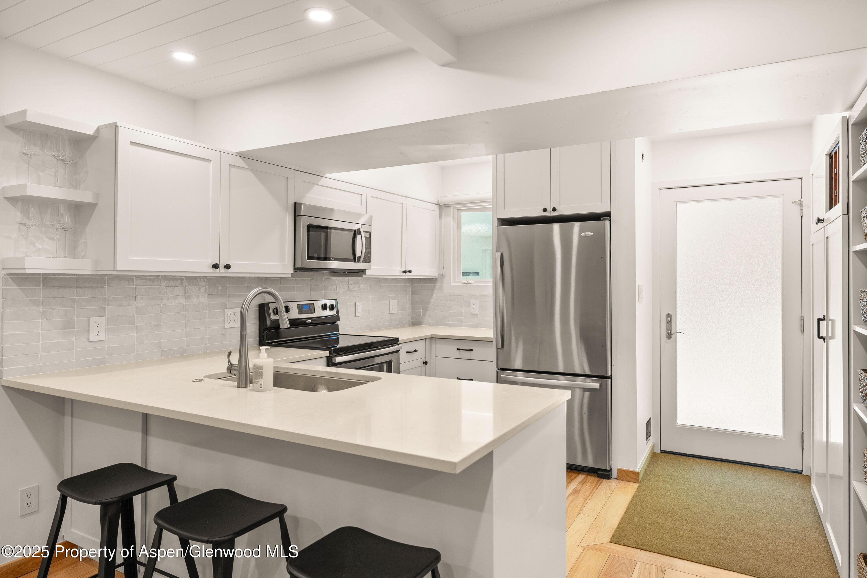 814 West Bleeker Street, Unit B2 Aspen, CO 81611 - Photo 8 of 17 a kitchen with a sink a refrigerator and chairs
