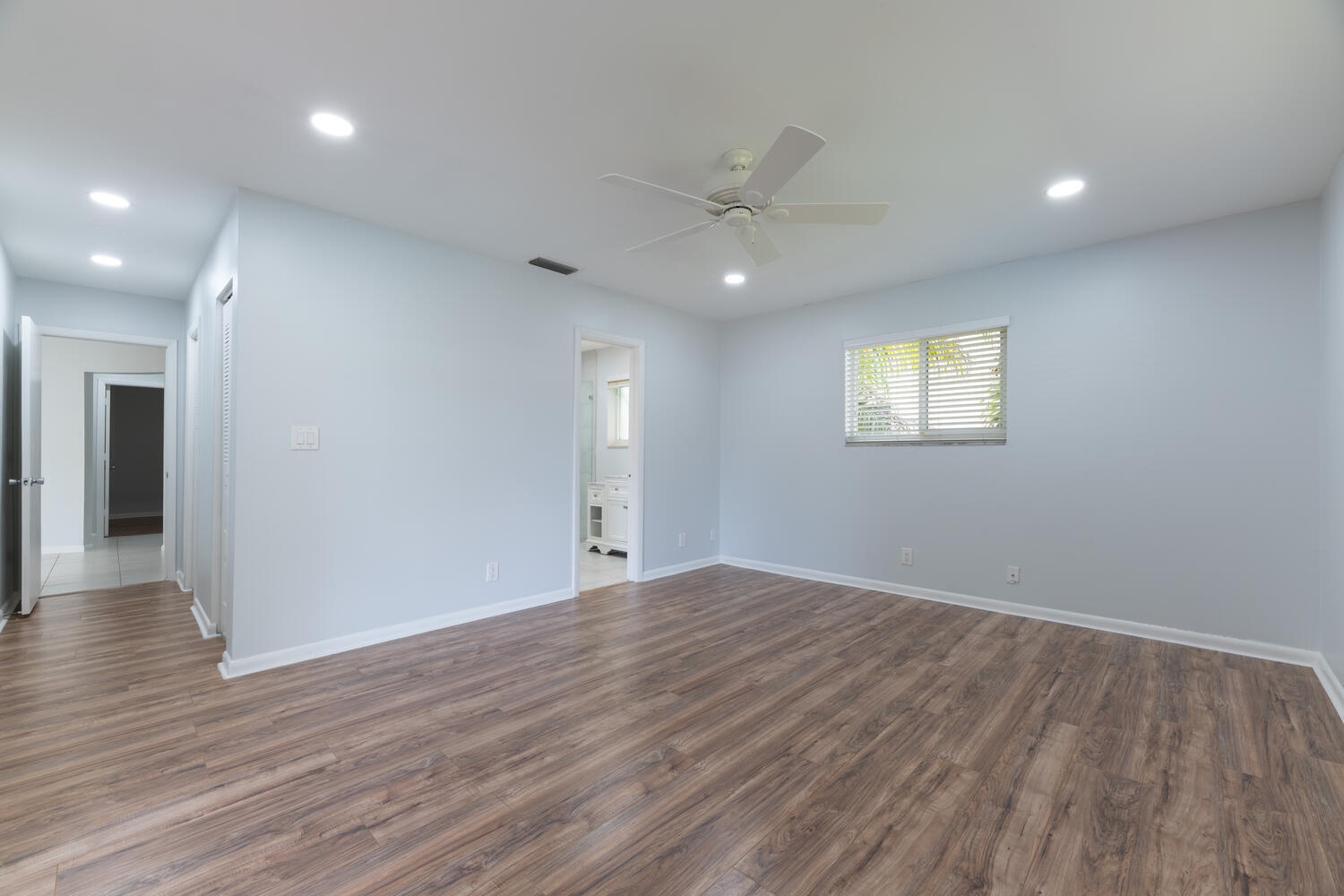 4695 Brandywine Drive Boca Raton, FL 33487 - Photo 17 of 28 an empty room with wooden floor and windows