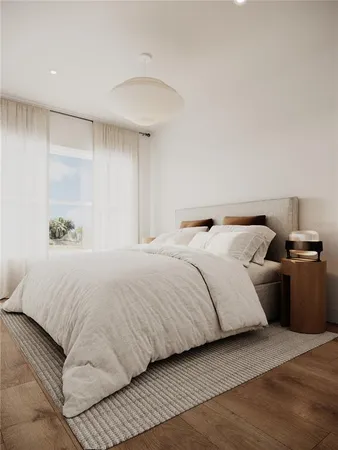 a bedroom with a large bed and a potted plant
