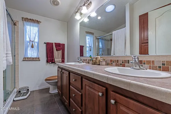 a bathroom with a double vanity sink mirror and toilet