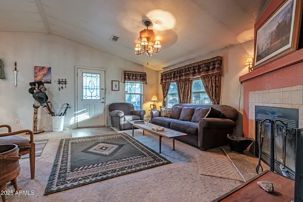 a living room with furniture a chandelier and a fireplace