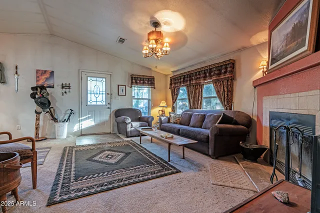 a living room with furniture a chandelier and a fireplace