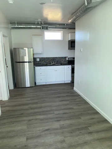 a kitchen with a refrigerator and a stove top oven