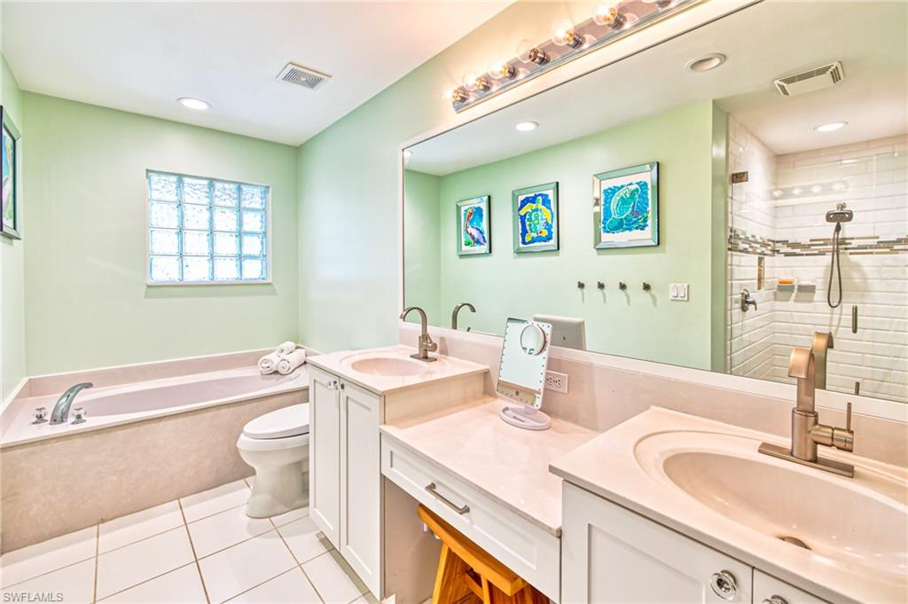 1638 Triangle Palm Terrace Naples, FL 34119 - Photo 12 of 30 a bathroom with a granite countertop sink mirror vanity bathtub and toilet