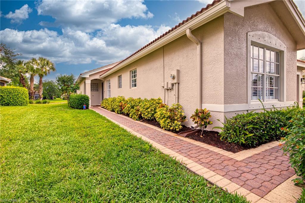 1638 Triangle Palm Terrace Naples, FL 34119 - Photo 17 of 30 a front view of house and yard with green space