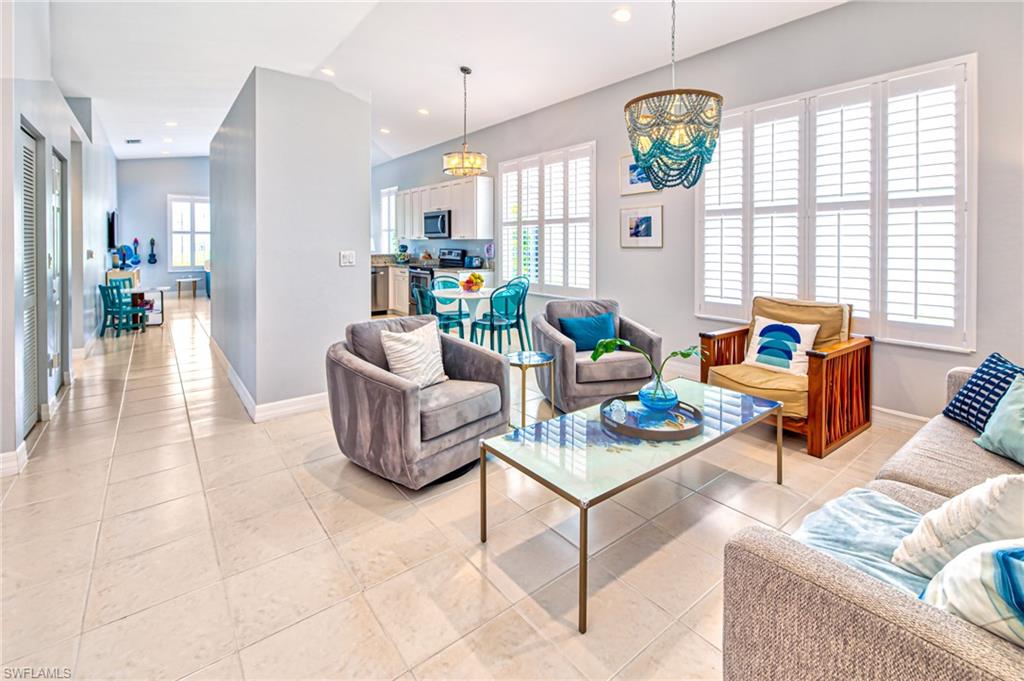 1638 Triangle Palm Terrace Naples, FL 34119 - Photo 3 of 30 a living room with fireplace furniture and a chandelier