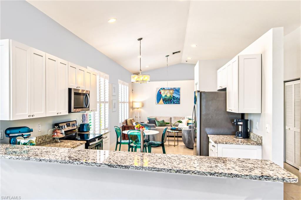 1638 Triangle Palm Terrace Naples, FL 34119 - Photo 6 of 30 a kitchen with stainless steel appliances kitchen island granite countertop a refrigerator and a stove top oven