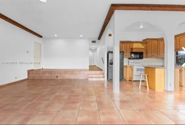 a view of a kitchen with a sink and a refrigerator