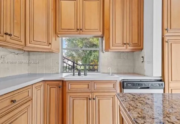 a kitchen with granite countertop white cabinets and stainless steel appliances