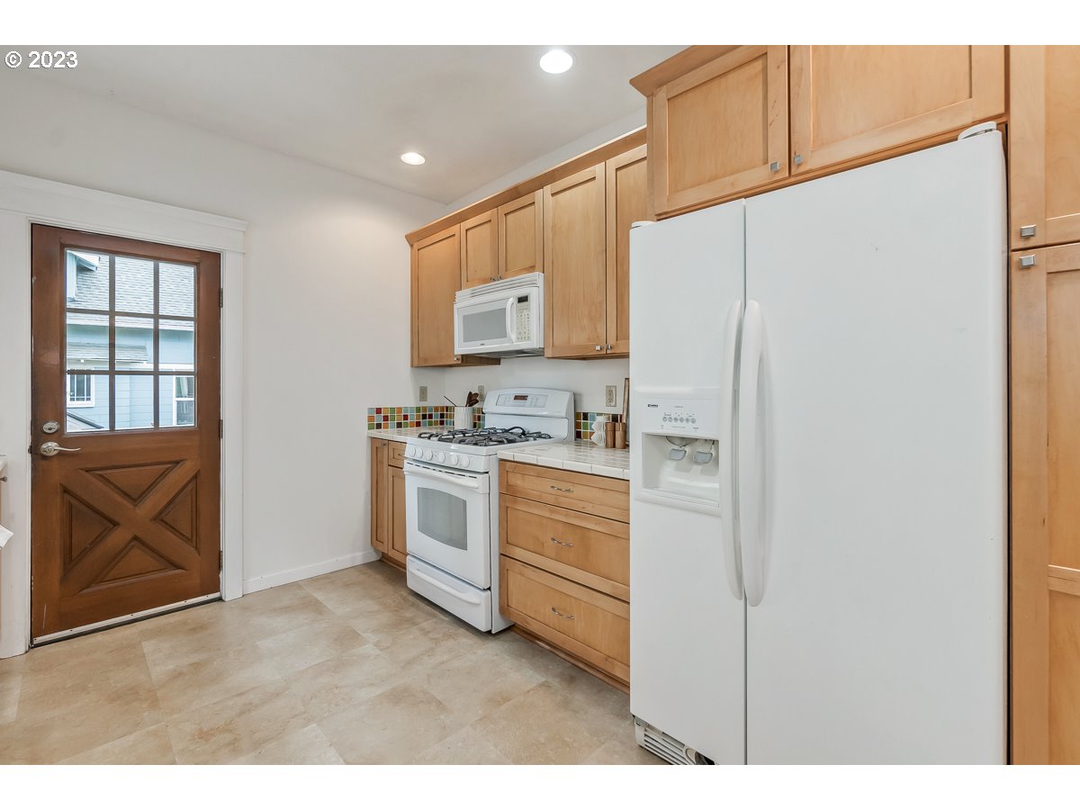 1410 Southeast 35th Avenue Portland, OR 97214 - Photo 13 of 39 a kitchen with white cabinets and white appliances