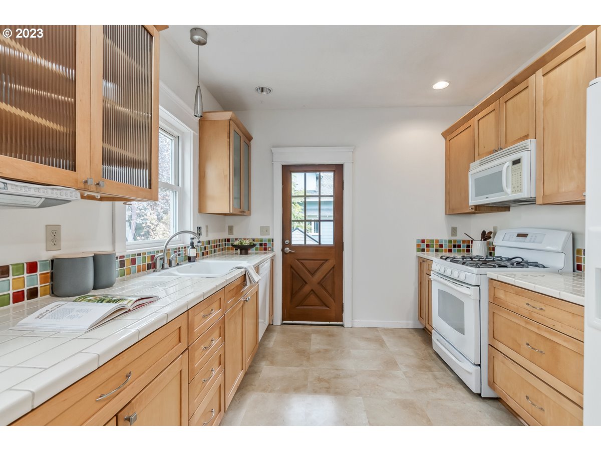 1410 Southeast 35th Avenue Portland, OR 97214 - Photo 15 of 39 a kitchen with stainless steel appliances granite countertop a sink and cabinets
