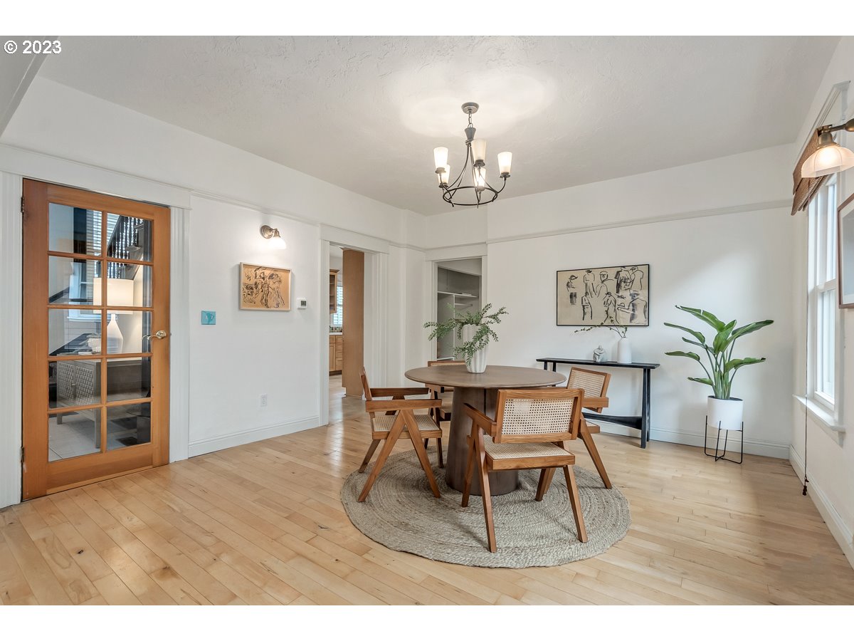 1410 Southeast 35th Avenue Portland, OR 97214 - Photo 8 of 39 a dining room with wooden floor a chandelier a wooden table and chairs