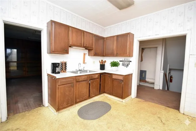 a kitchen with a sink a refrigerator and cabinets