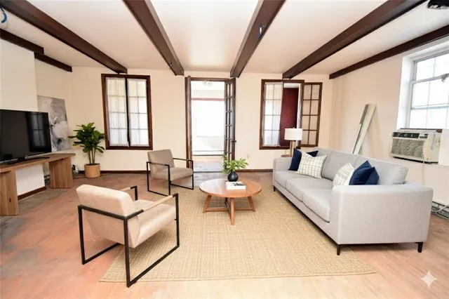 a living room with furniture large windows and a flat screen tv