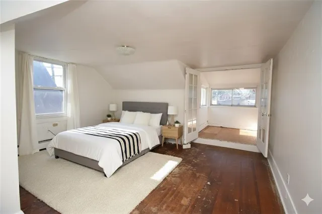 a bedroom with a bed and wooden floor