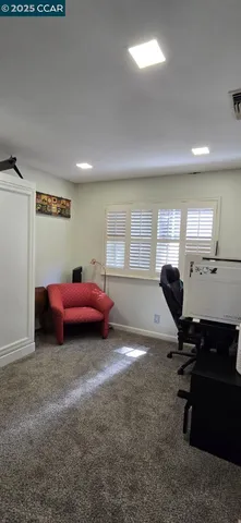 a view of a workspace with furniture and a window