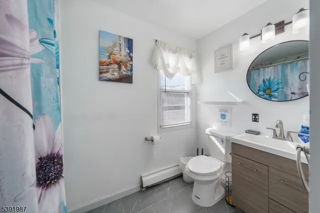 a bathroom with a toilet a sink and mirror