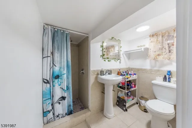 a bathroom with a toilet sink and shower curtain