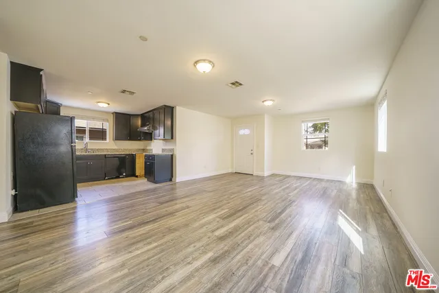 a view of kitchen with refrigerator microwave and wooden floor