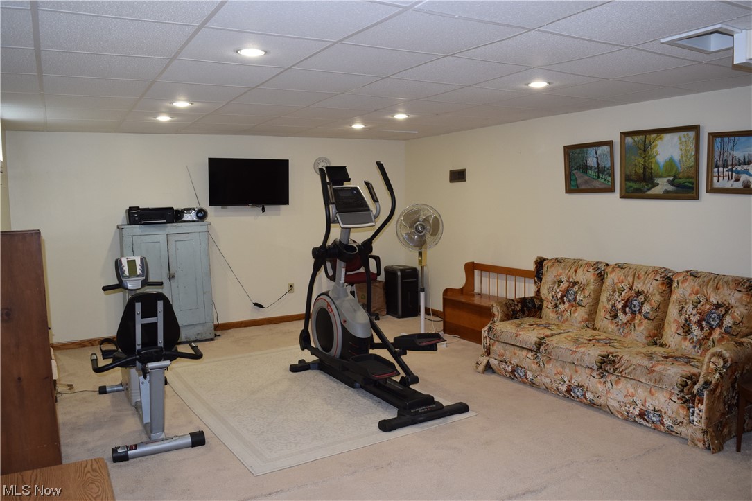65578 Mathews Road Cambridge, OH 43725 - Photo 20 of 40 Family room with light colored carpet and a paneled ceiling