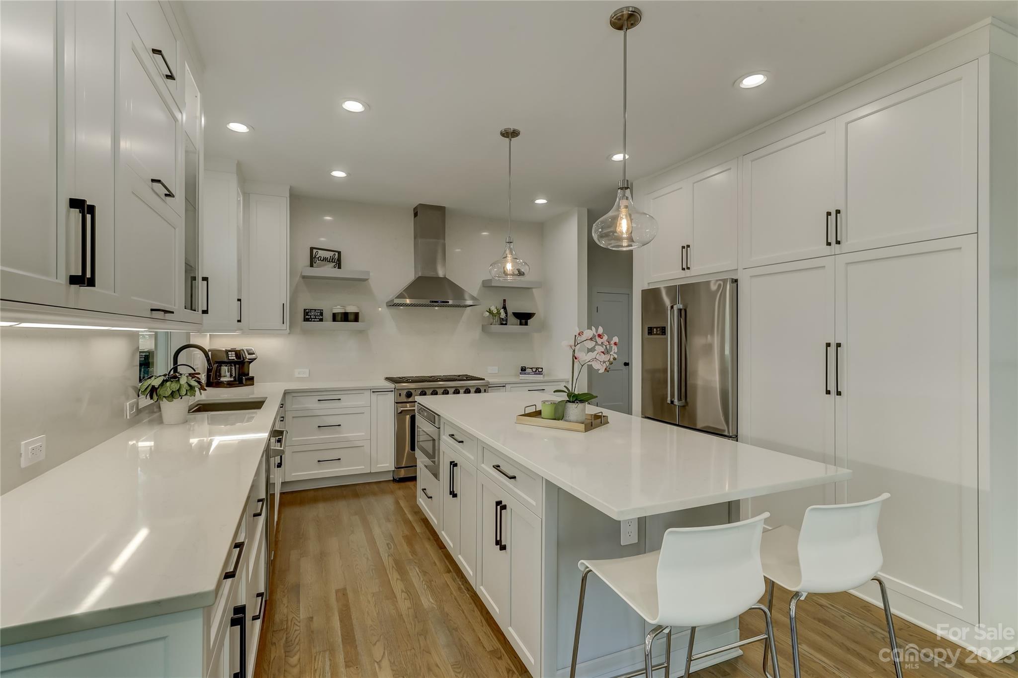 4308 Rosecliff Drive Charlotte, NC 28277 - Photo 11 of 39 a large kitchen with stainless steel appliances a stove a sink a refrigerator white cabinets and wooden floor