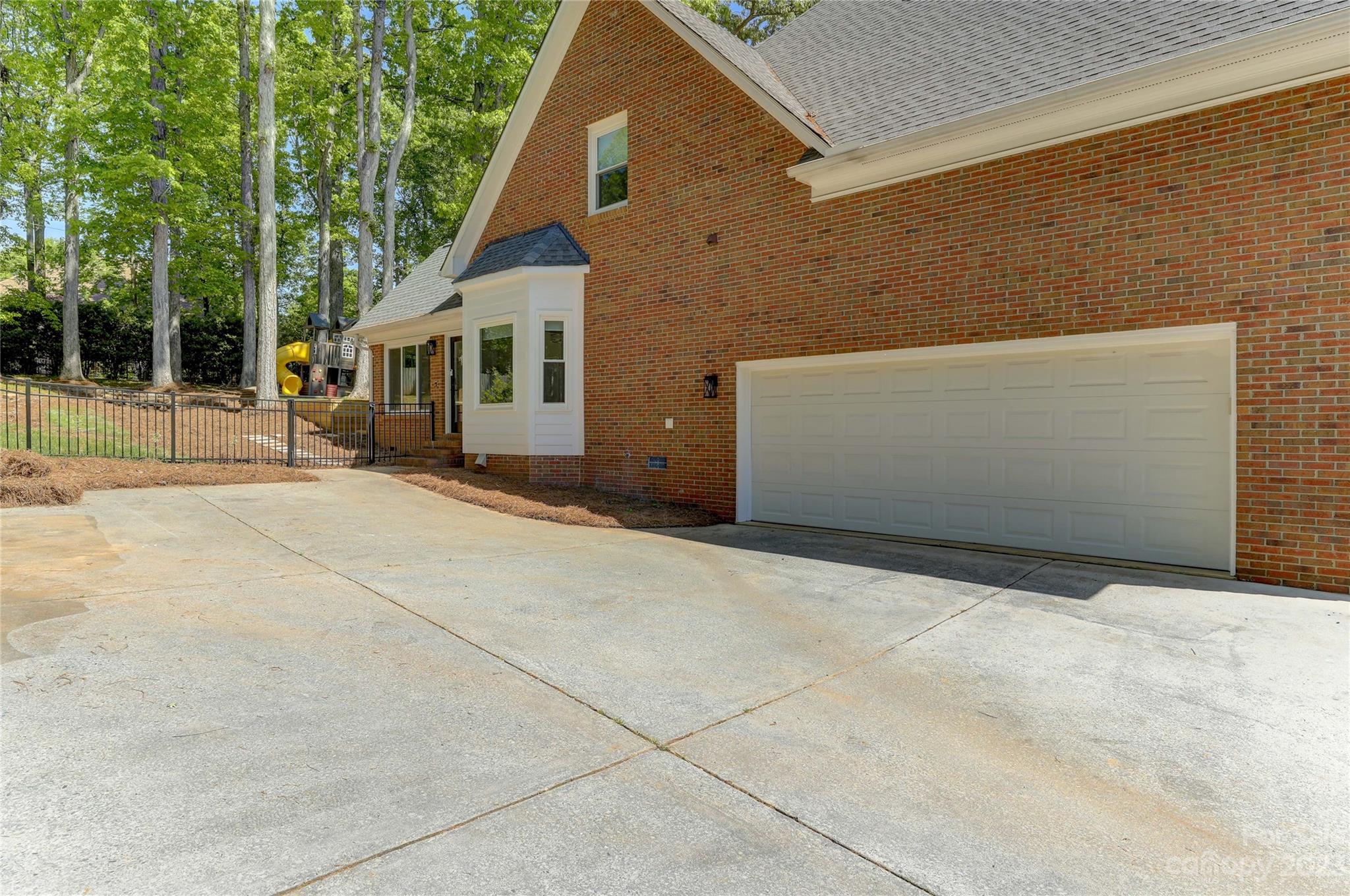 4308 Rosecliff Drive Charlotte, NC 28277 - Photo 39 of 39 a backyard of a house with large trees and brick walls