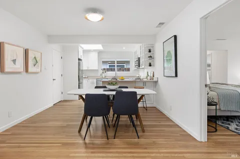 a kitchen with stainless steel appliances a sink a stove a refrigerator cabinets and dining table