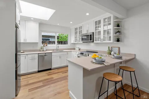a kitchen with stainless steel appliances white cabinets and a stove top oven
