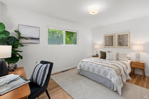 a bedroom with a bed table and a window