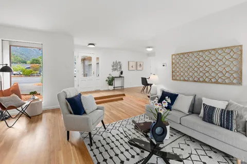 a view of a room with furniture and wooden floor