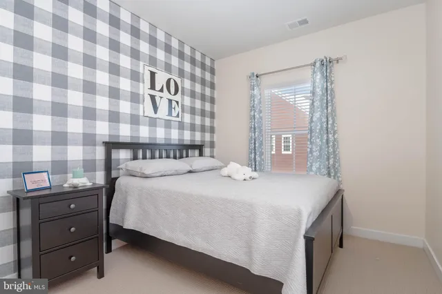 a bedroom with a bed and a lamp on dresser