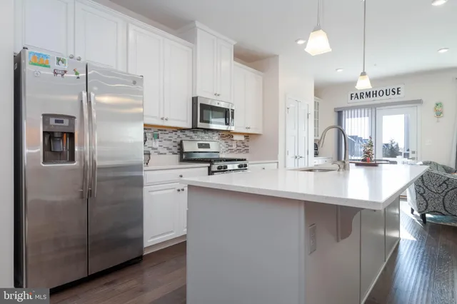 a kitchen with stainless steel appliances a refrigerator sink and microwave
