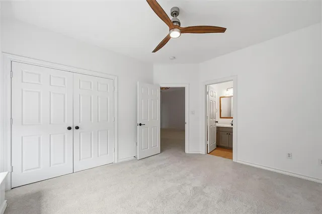 a view of a big room with windows and chandelier fan