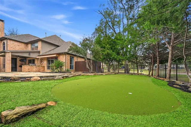 a view of a house with a big yard potted plants and large tree
