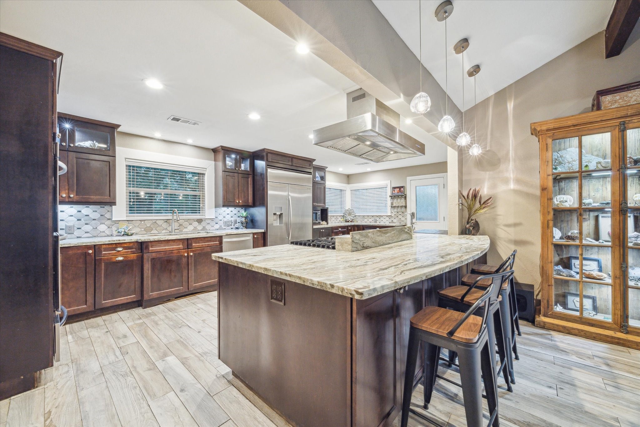 a kitchen with stainless steel appliances granite countertop a kitchen island a stove a table and chairs in it