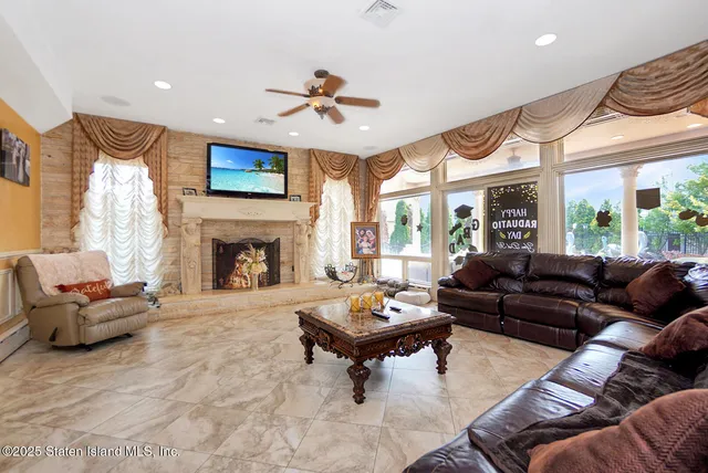 a living room with furniture fireplace and a large window