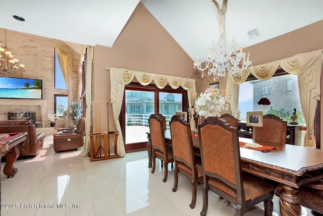 a dining hall with stainless steel appliances kitchen island granite countertop a stove a sink and a dining table