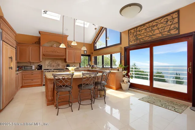 a kitchen with a stove a counter space a large window and chairs