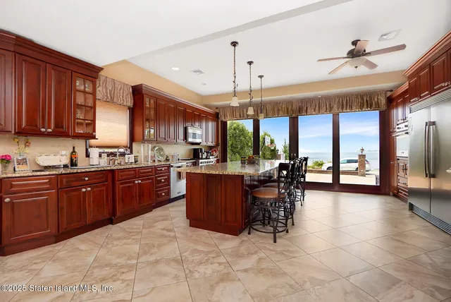 a kitchen with a refrigerator a stove top oven and a dining table with wooden floor