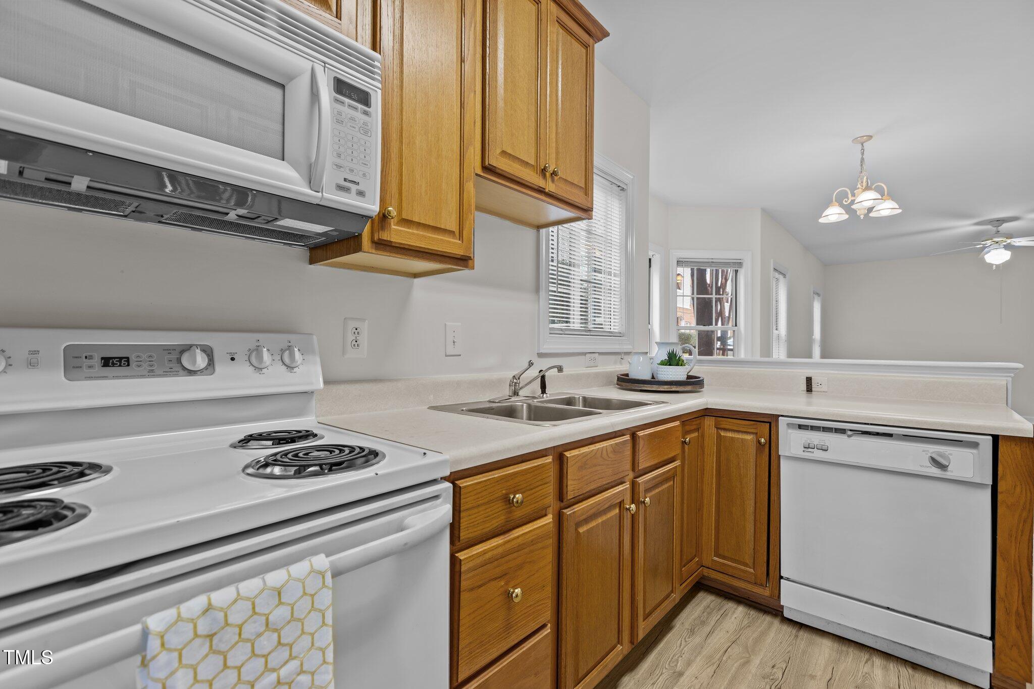 7022 Sandy Forks Road, Unit 101 Raleigh, NC 27615 - Photo 13 of 40 a kitchen with stainless steel appliances a stove a sink dishwasher and cabinets with wooden floor