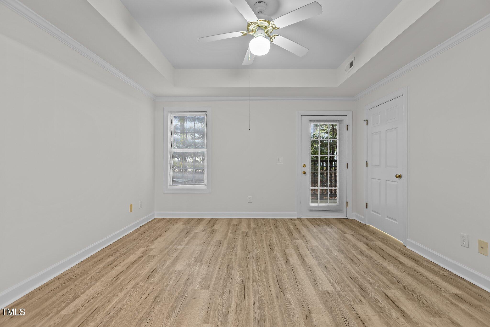 7022 Sandy Forks Road, Unit 101 Raleigh, NC 27615 - Photo 15 of 40 a view of an empty room with wooden floor and a window