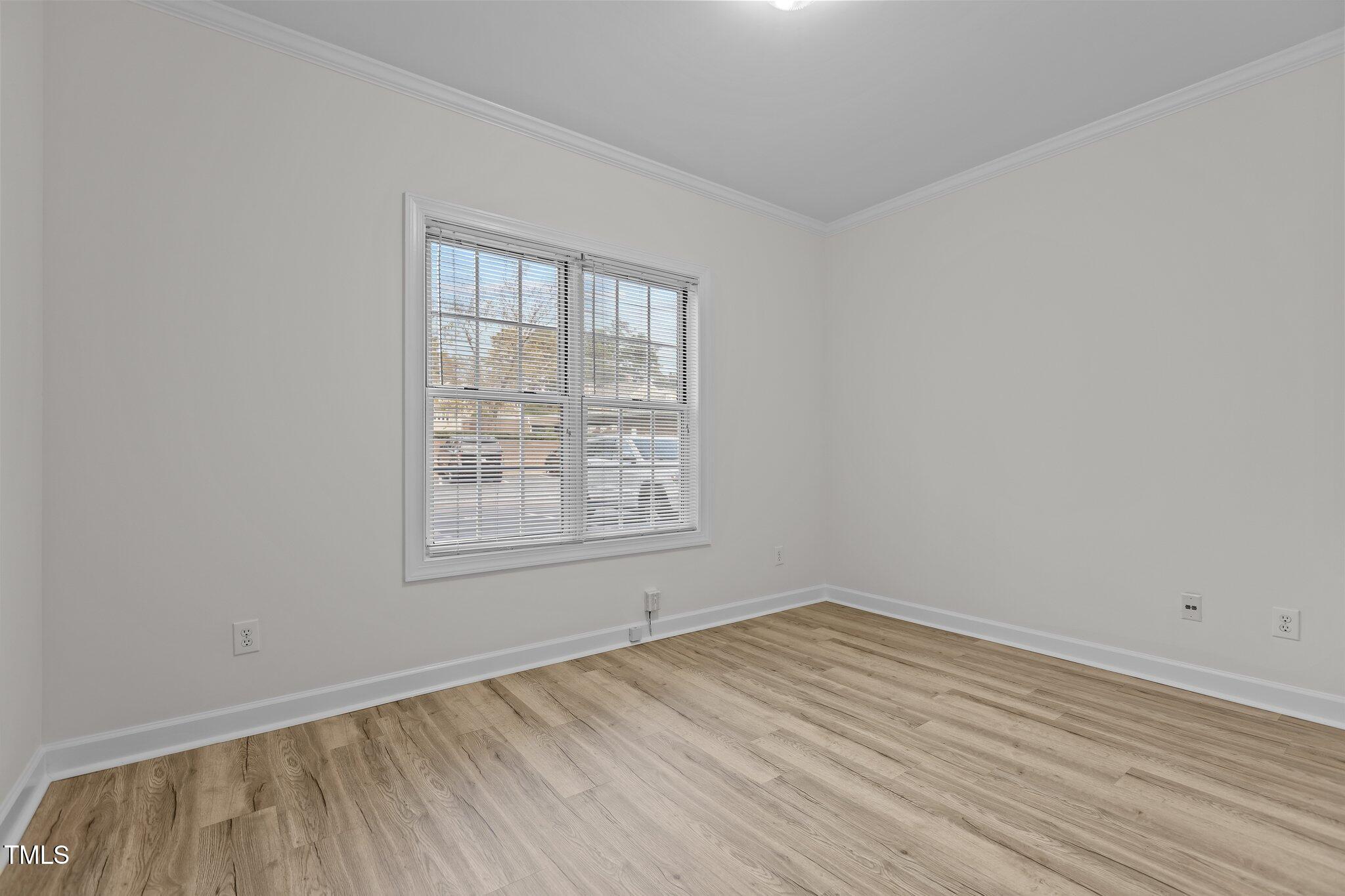 7022 Sandy Forks Road, Unit 101 Raleigh, NC 27615 - Photo 21 of 40 an empty room with wooden floor and windows