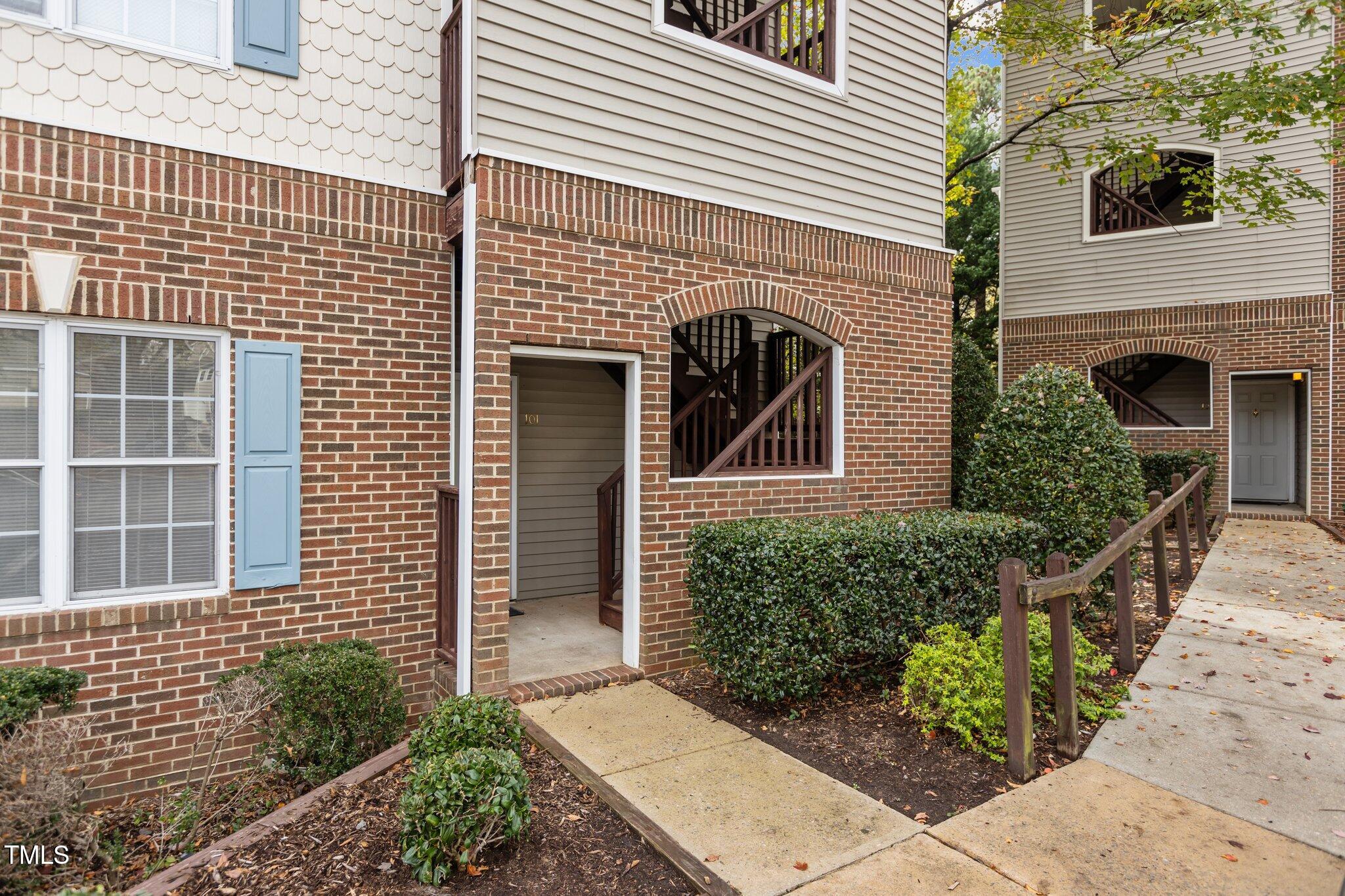 7022 Sandy Forks Road, Unit 101 Raleigh, NC 27615 - Photo 3 of 40 a front view of a house with a garden